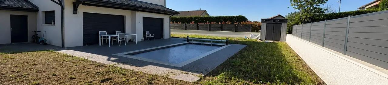 Terrain en terre nue et herbes éparses autour d’une piscine, devant une maison récente.